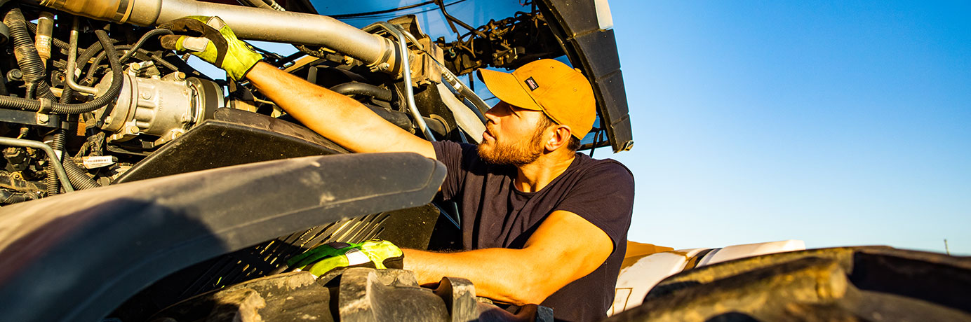 Man checking the engine on a tractor