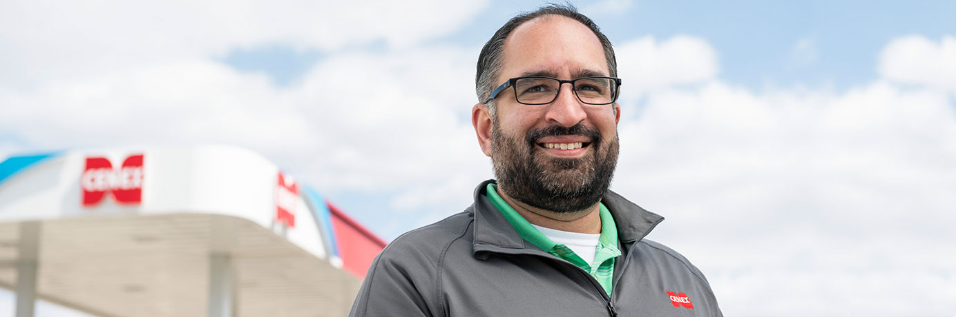 Akhtar smiling in front of a Cenex canopy