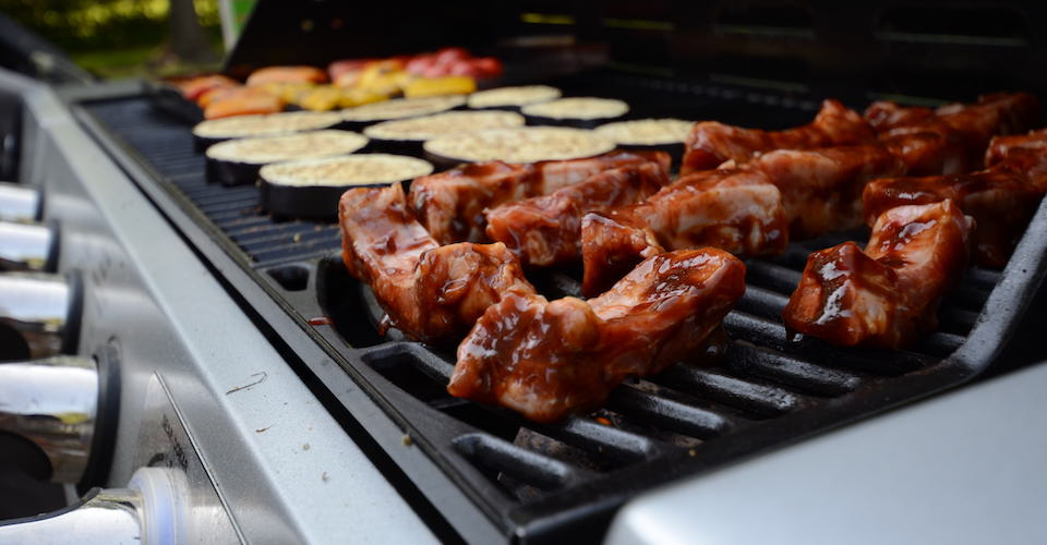 Food cooking on propane-powered grill.