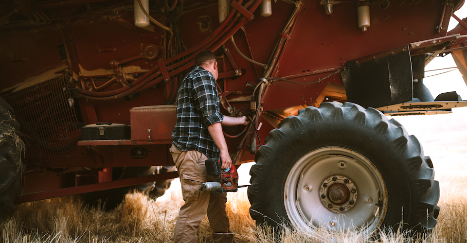 Man looking at combine harvester