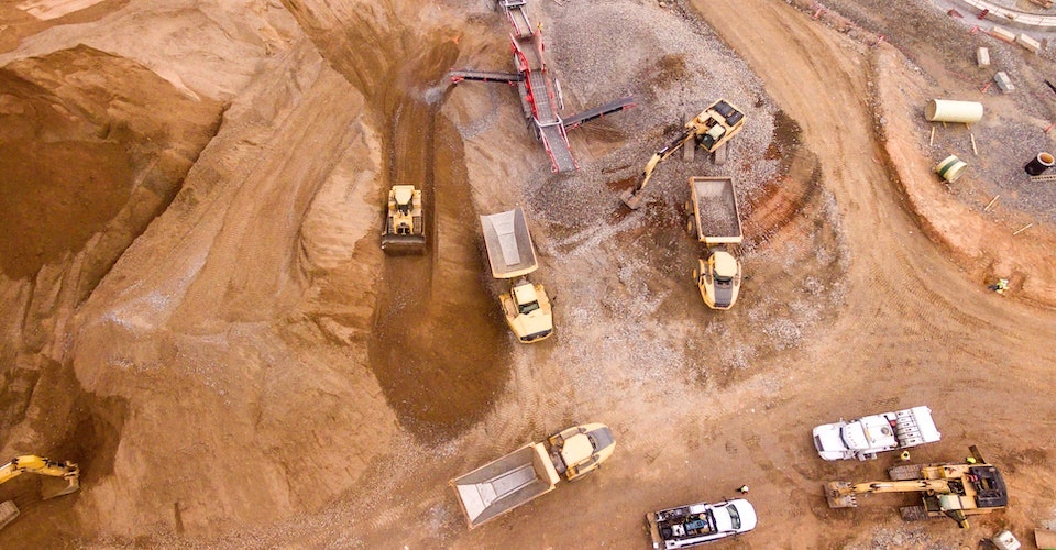 Aerial shot of many construction vehicles working at a site