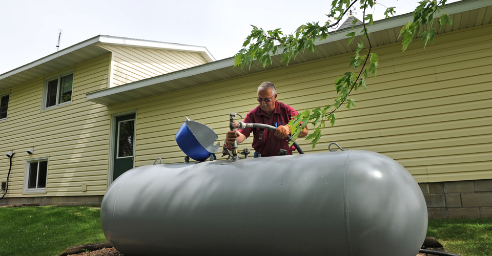 Filling the propane tank behind a house