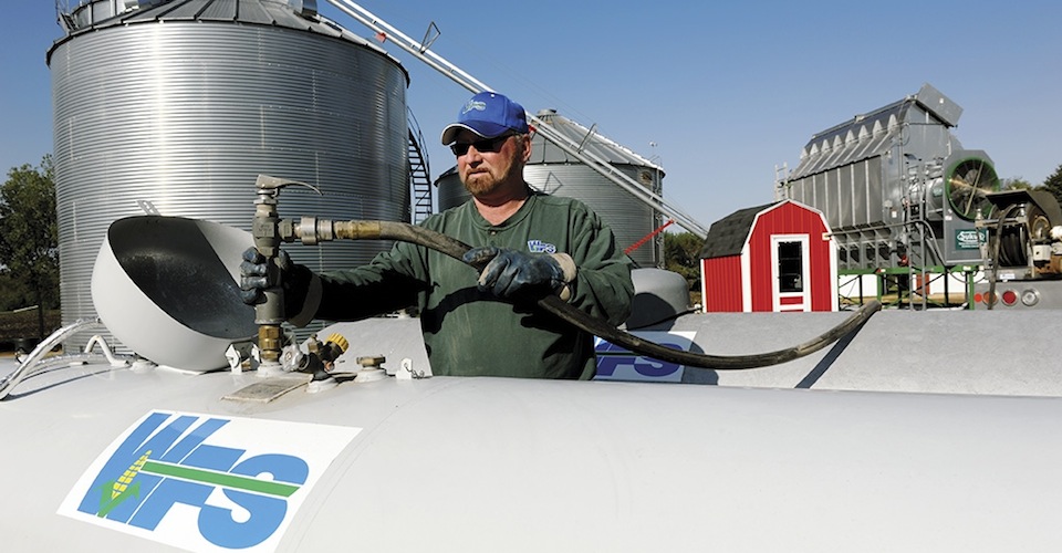 Hooking up a hose to the propane tank on the farm