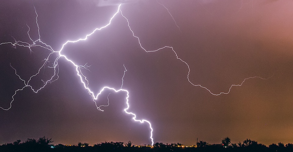 Lightning striking in the dark sky