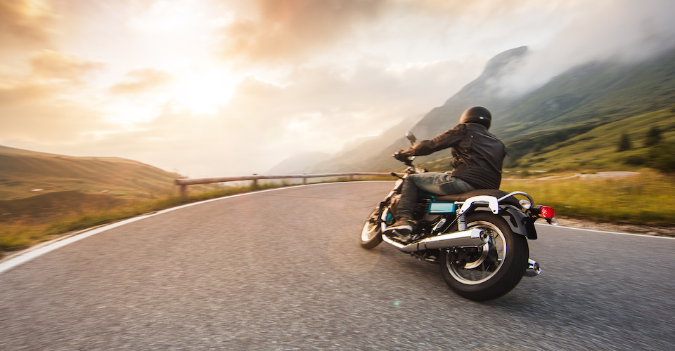 Motorcycle driving up a mountain on a winding road