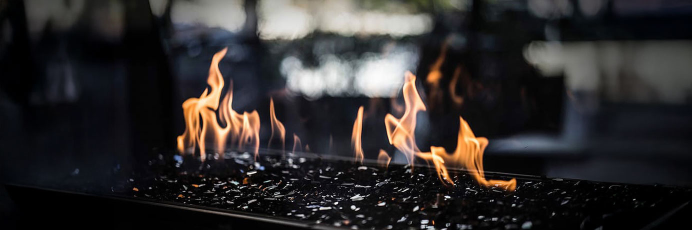 A propane-powered fire in a fireplace outside at night