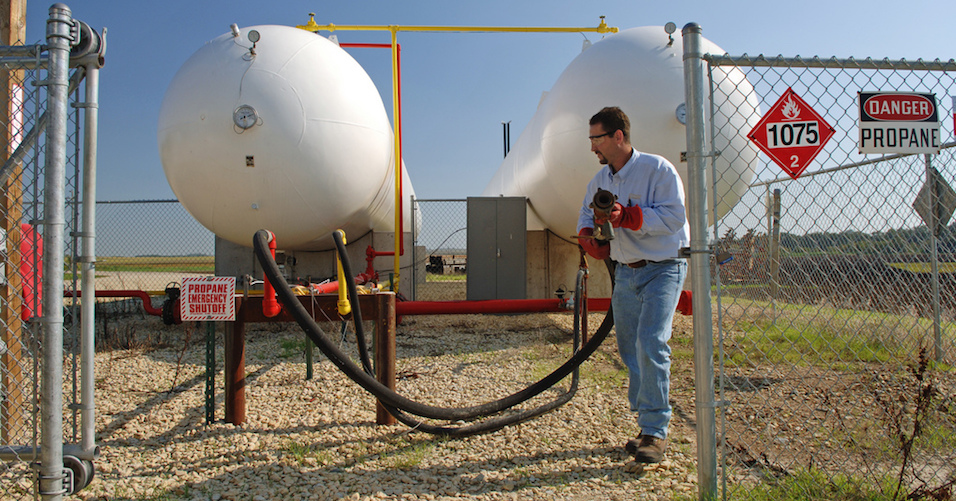 Man pulling hose from propane tank