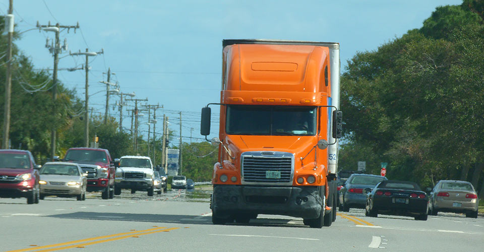 Semi truck driving down a busy street