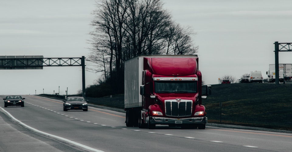 Semi truck and cars driving down a freeway