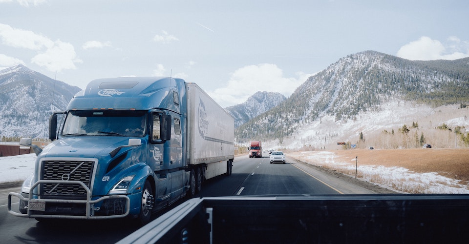 Semi truck driving away from the mountains
