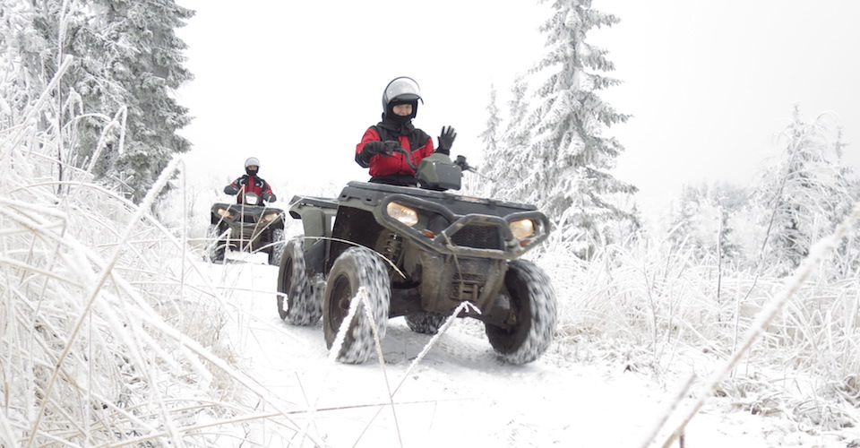 Riding snowmobiles down a snowy path