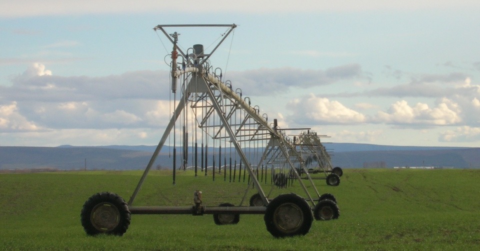 Sprinkler on a field in front of hills
