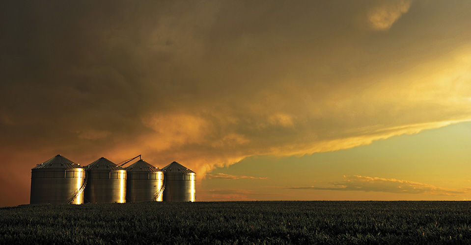 Grain bins in front of a sunset