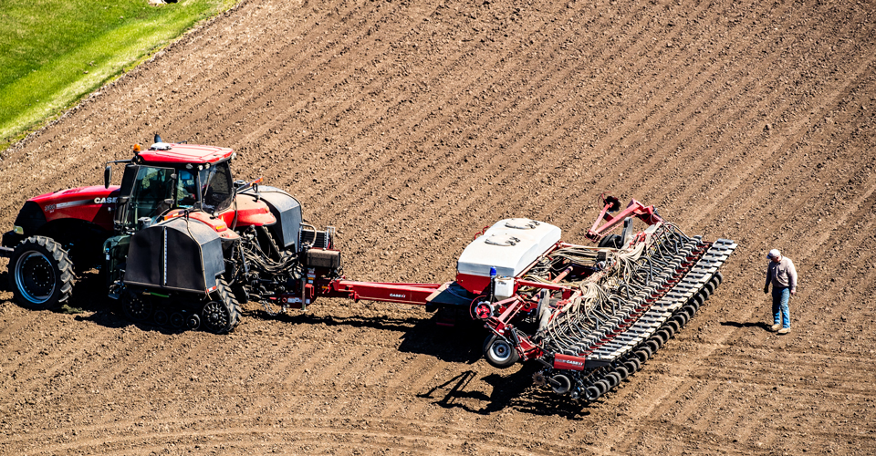 Farmer inspecting planter in a field