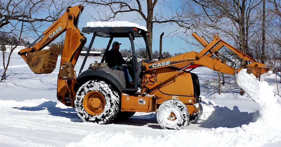 A yellow snow plow truck removing snow.