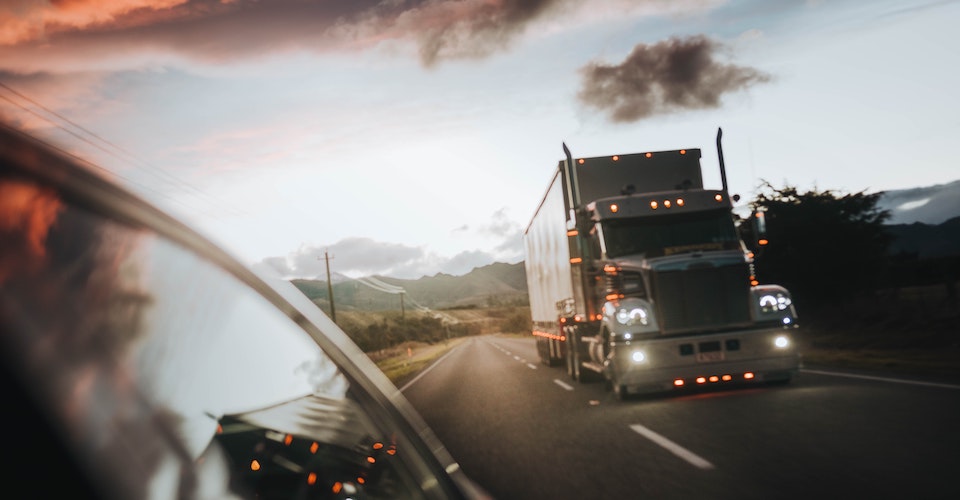 Semi truck driving away from the mountains