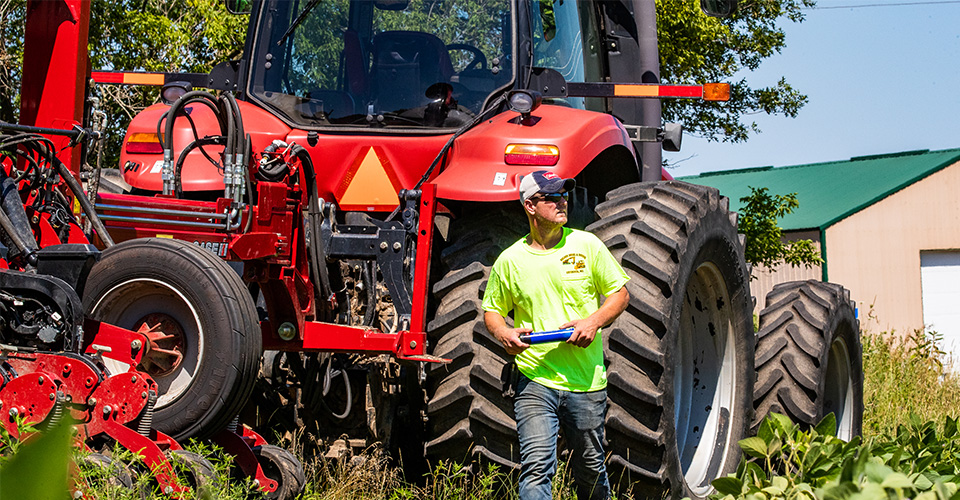 Man walking in front of a tractor