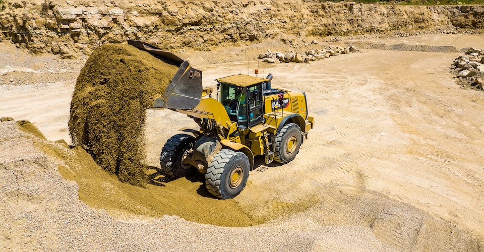 Wheel loader scooping up dirt at a construction site